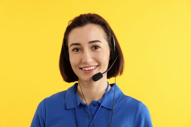 Photo of Technical support call center. Portrait of smiling operator on yellow background