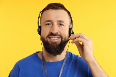 Photo of Technical support call center. Portrait of smiling operator on yellow background