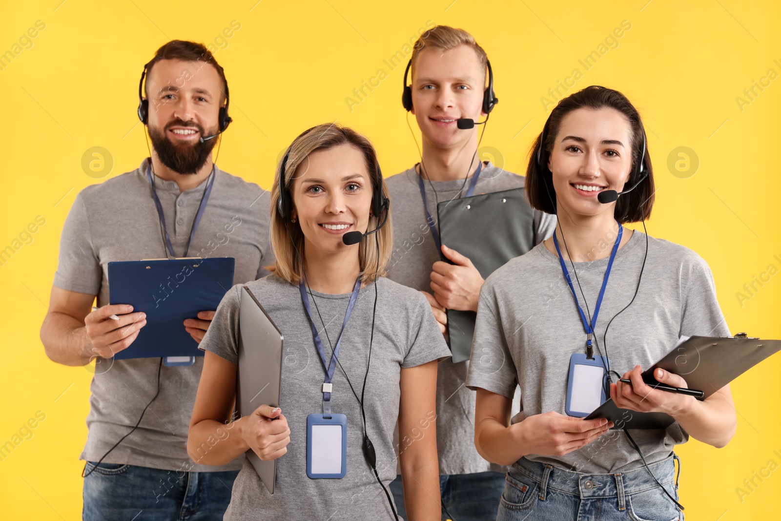 Photo of Technical support call center. Team of friendly operators on yellow background