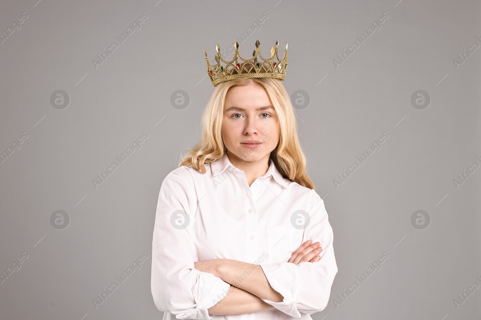 Photo of Woman in elegant crown with crossed arms on grey background