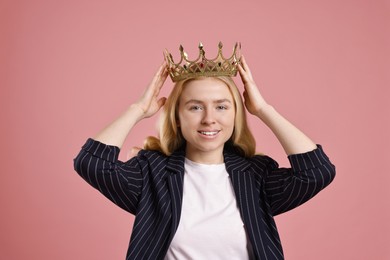 Photo of Smiling businesswoman in elegant crown on dusty pink background