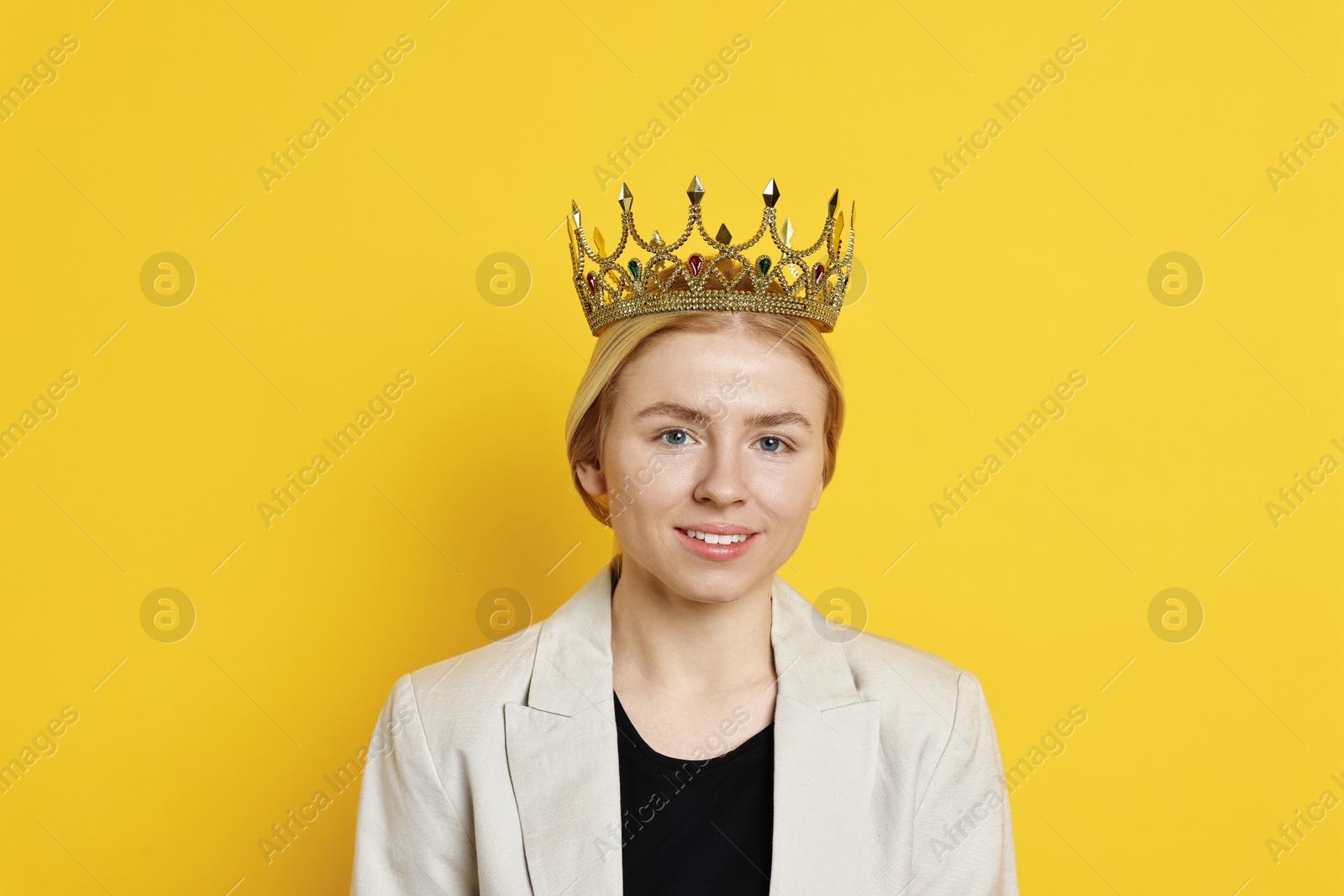 Photo of Smiling businesswoman in elegant crown on yellow background