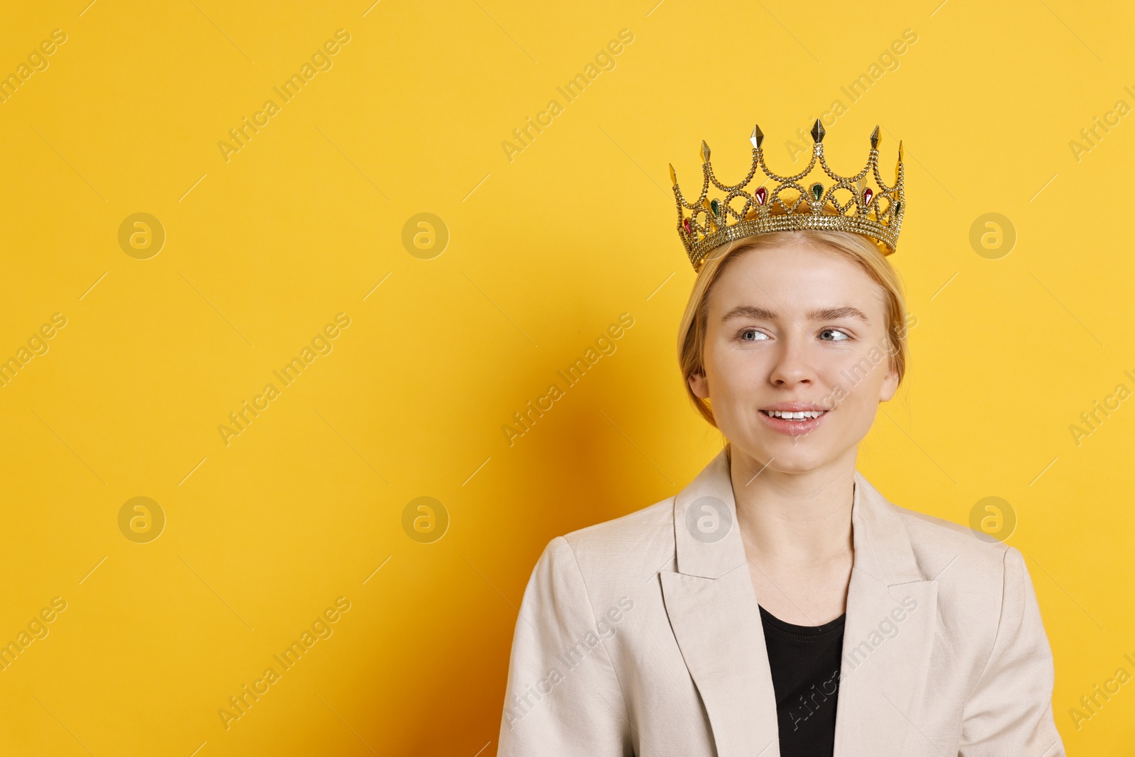 Photo of Smiling businesswoman in elegant crown on yellow background. Space for text