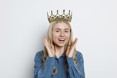 Happy woman in elegant crown on light background