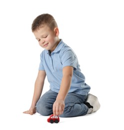 Little boy playing with toy car on white background