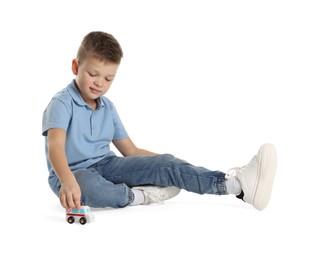 Little boy playing with toy car on white background