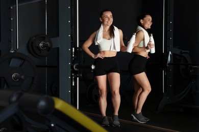 Photo of Happy woman with towel and water bottle in gym