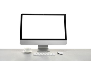 Photo of Computer monitor, keyboard, mouse and cup of drink on grey desk against white background