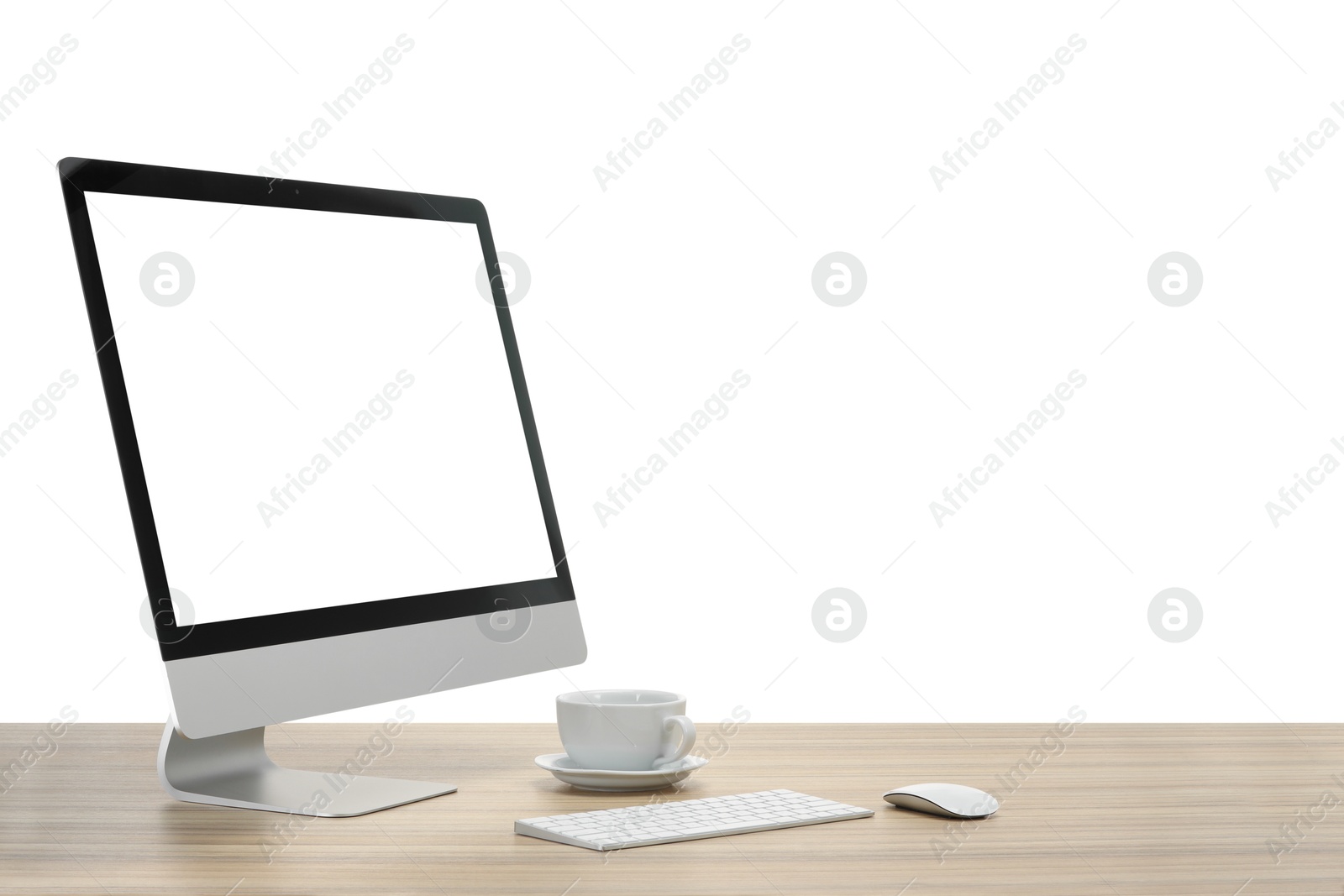 Photo of Computer monitor, keyboard, mouse and cup of drink on wooden desk against white background