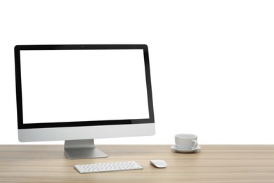 Photo of Computer monitor, keyboard, mouse and cup of drink on wooden desk against white background