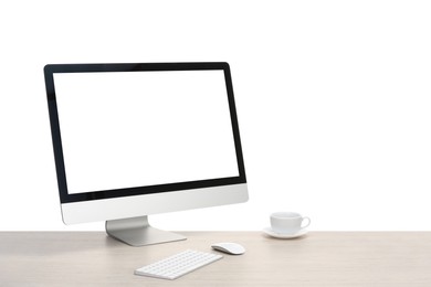 Photo of Computer monitor, keyboard, mouse and cup of drink on wooden desk against white background