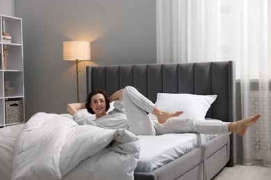 Photo of Young woman exercising on bed at home. Morning routine