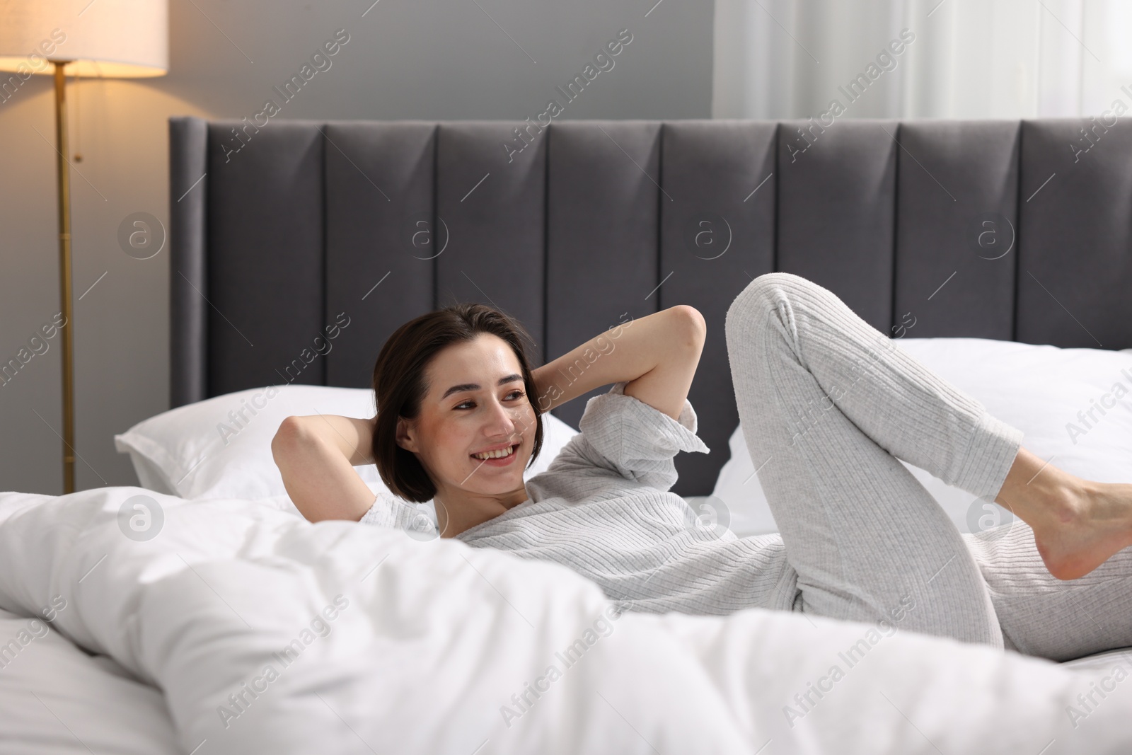 Photo of Young woman exercising on bed at home. Morning routine