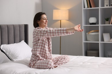 Young woman exercising on bed at home. Morning routine