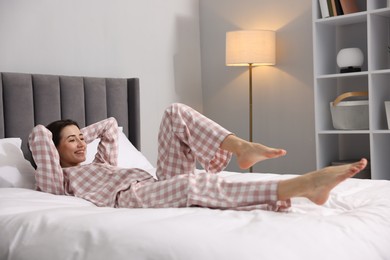 Young woman exercising on bed at home. Morning routine