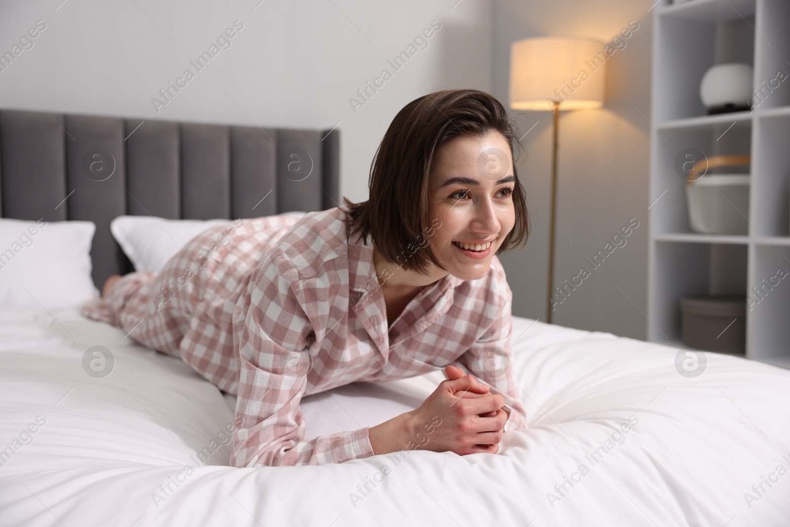 Photo of Young woman exercising on bed at home. Morning routine