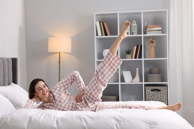 Young woman exercising on bed at home. Morning routine