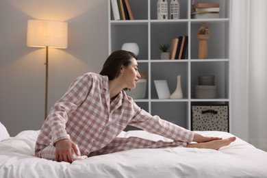 Young woman exercising on bed at home. Morning routine