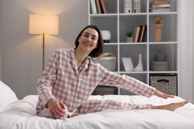 Young woman exercising on bed at home. Morning routine