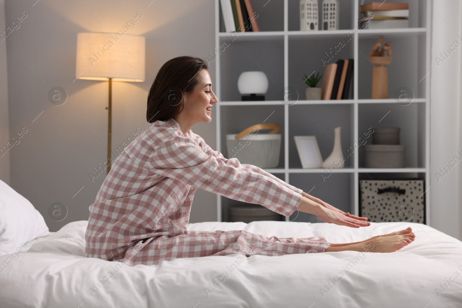 Photo of Young woman exercising on bed at home. Morning routine