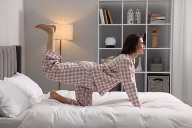 Photo of Young woman exercising on bed at home. Morning routine