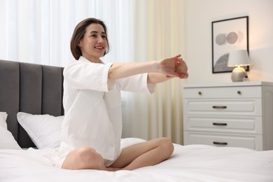 Young woman exercising on bed at home. Morning routine