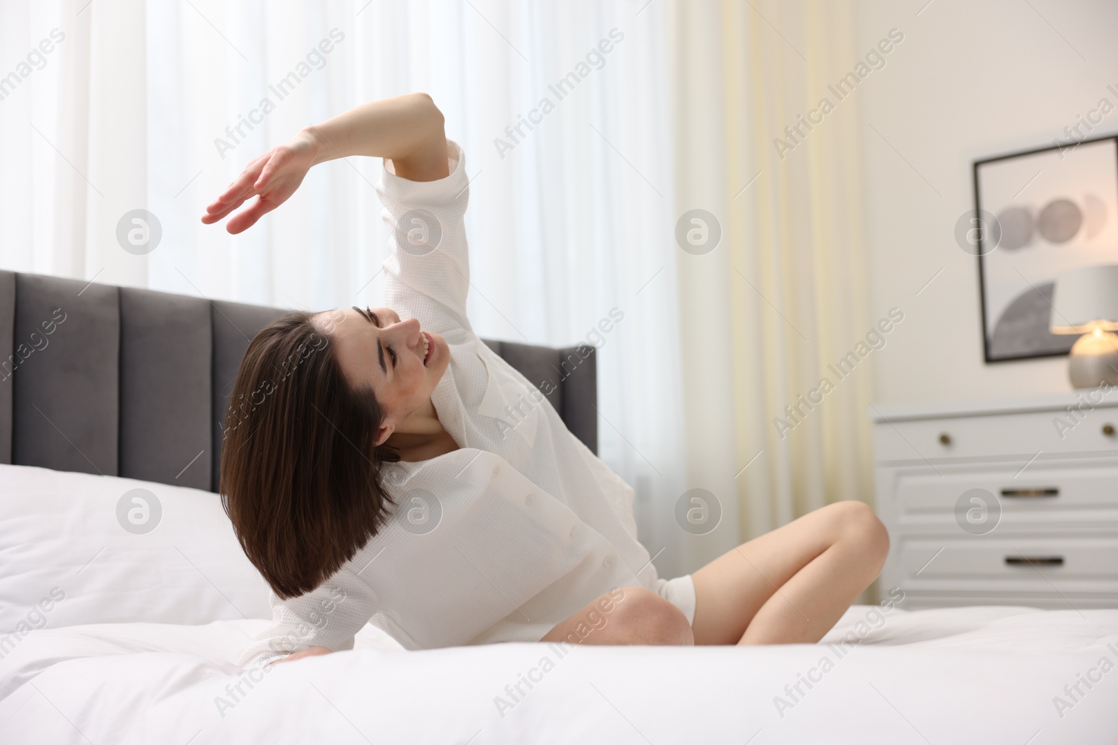 Photo of Young woman exercising on bed at home. Morning routine