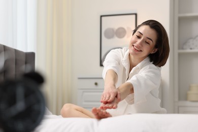 Photo of Young woman exercising on bed at home. Morning routine