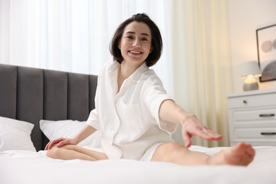 Young woman exercising on bed at home. Morning routine