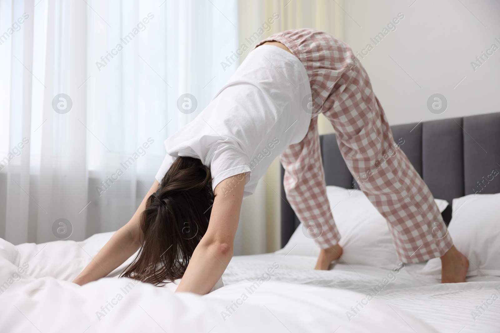 Photo of Young woman exercising on bed at home. Morning routine