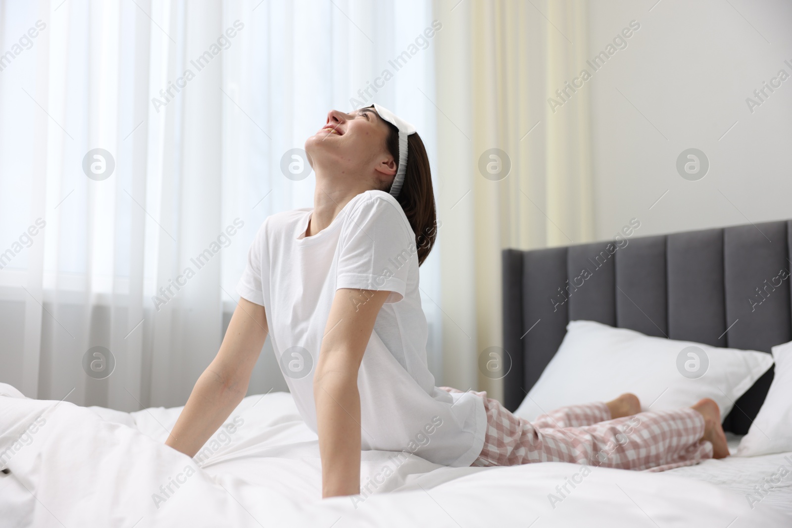 Photo of Young woman exercising on bed at home. Morning routine