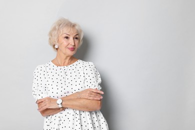 Portrait of grandmother on light grey background. Space for text