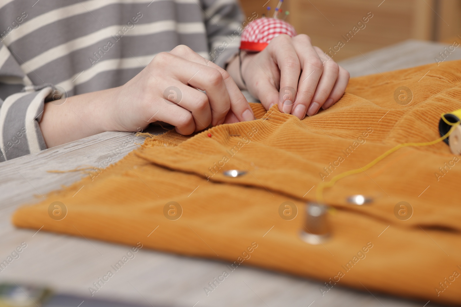 Photo of Woman working with cloth at light table indoors, closeup