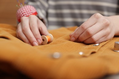 Photo of Woman with cloth and spool of sewing thread, closeup