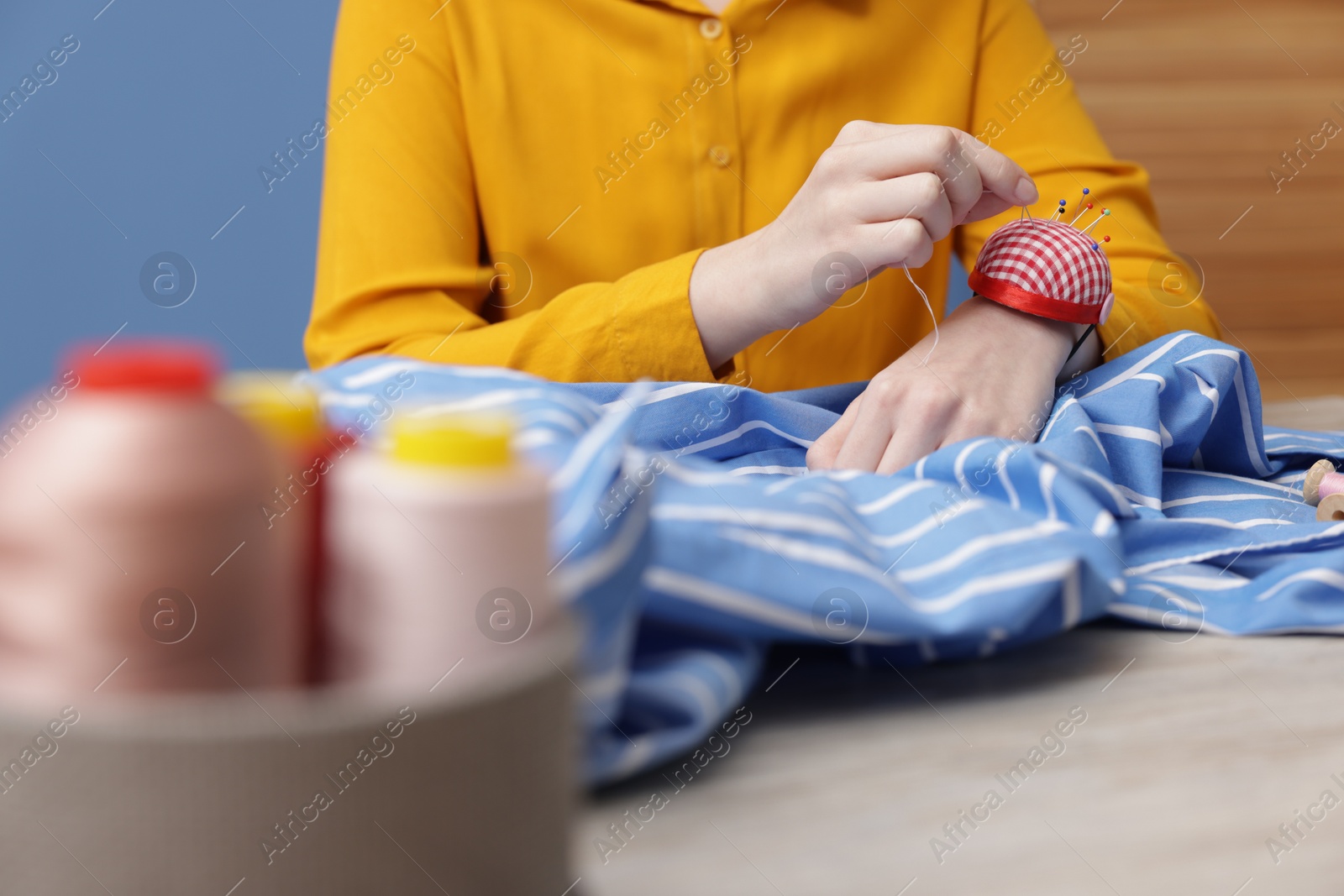 Photo of Woman working with cloth at light table indoors, selective focus