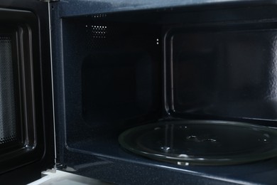 Photo of Open empty microwave oven, closeup. Inside view