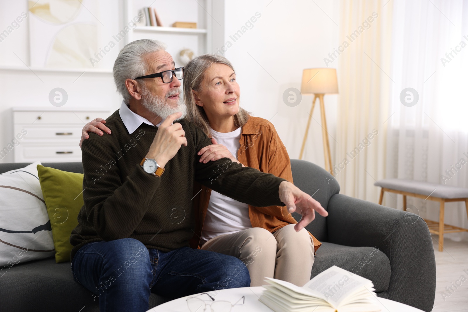 Photo of Elderly couple spending time together on sofa at home