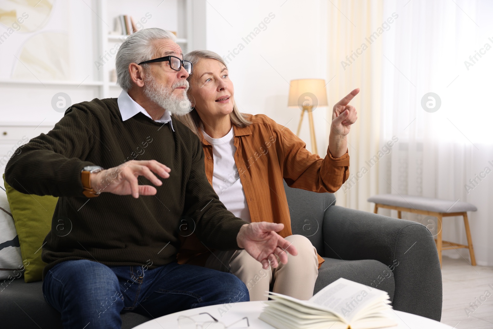 Photo of Elderly couple spending time together on sofa at home