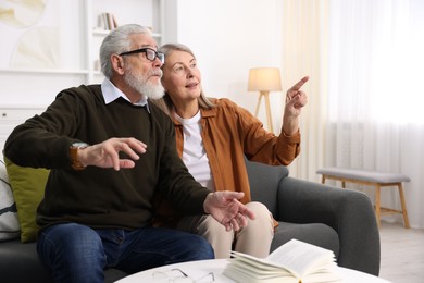 Elderly couple spending time together on sofa at home