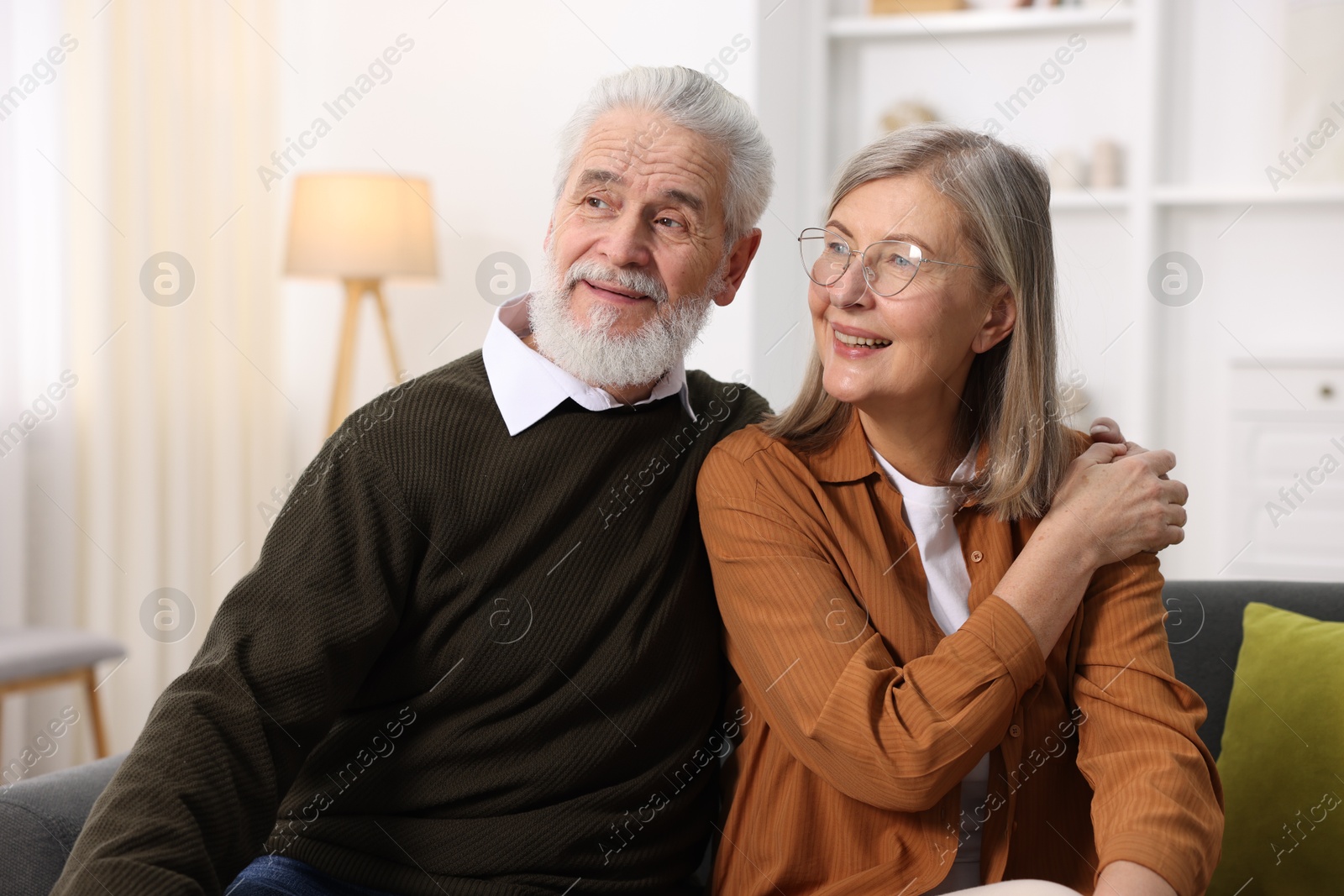 Photo of Happy elderly couple on sofa at home