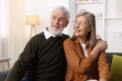 Photo of Happy elderly couple on sofa at home