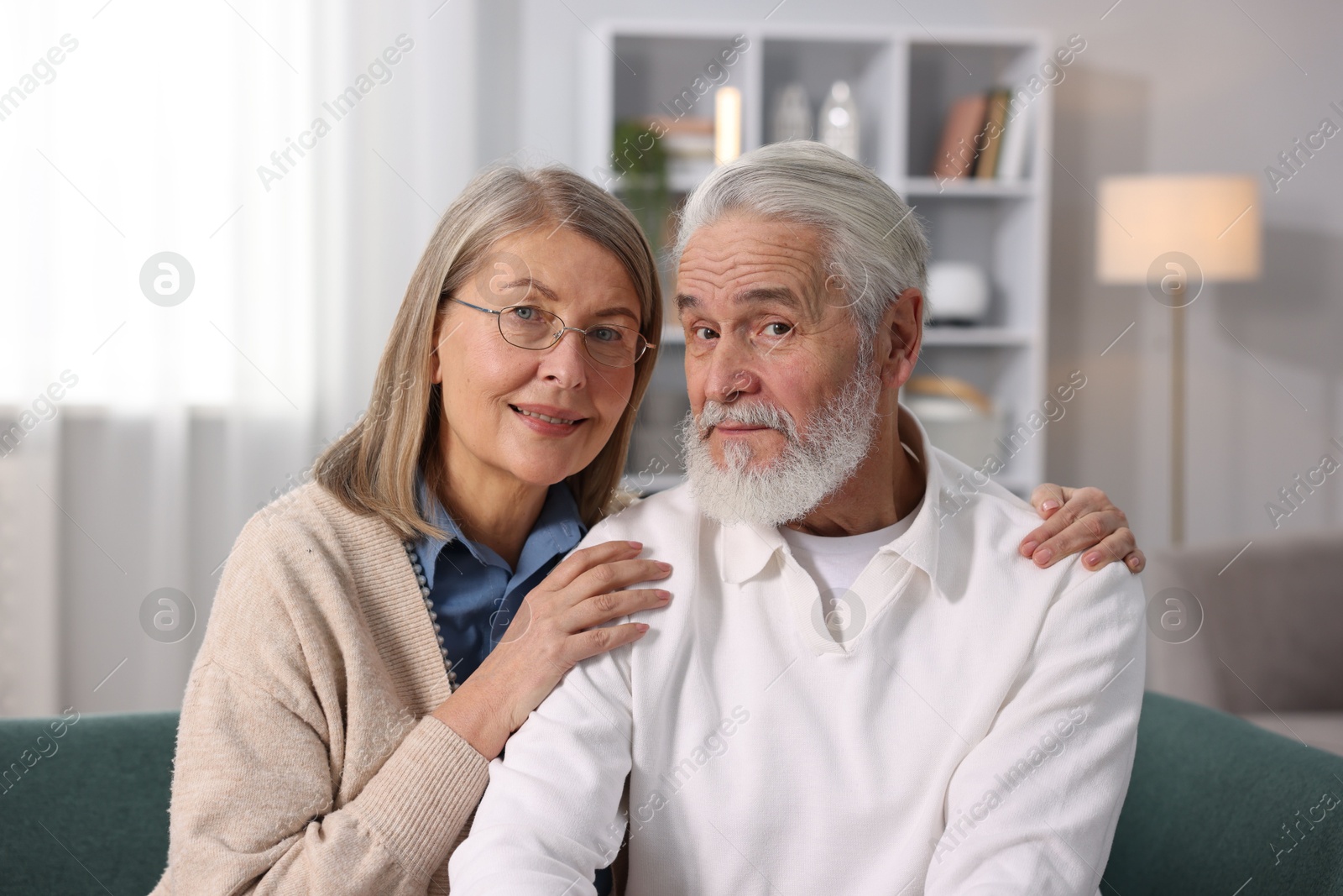 Photo of Portrait of cute elderly couple on sofa at home