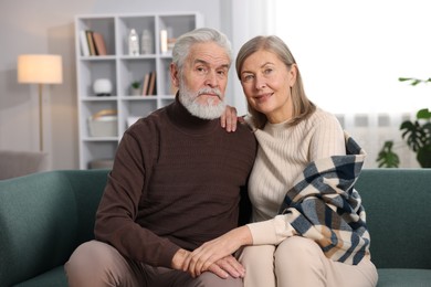 Photo of Portrait of cute elderly couple on sofa at home