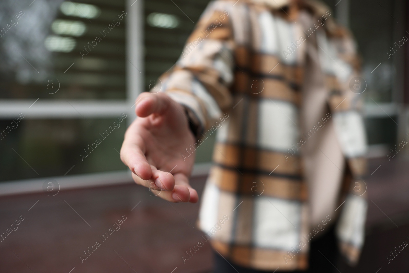 Photo of Offering help. Man reaching his hand outdoors, closeup