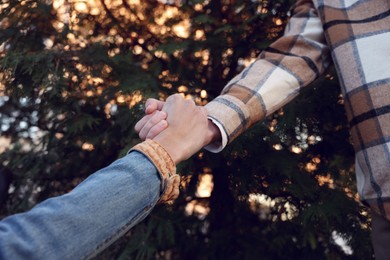 Help and support. People holding hands outdoors, closeup