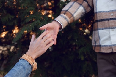 Help and support. People holding hands outdoors, closeup