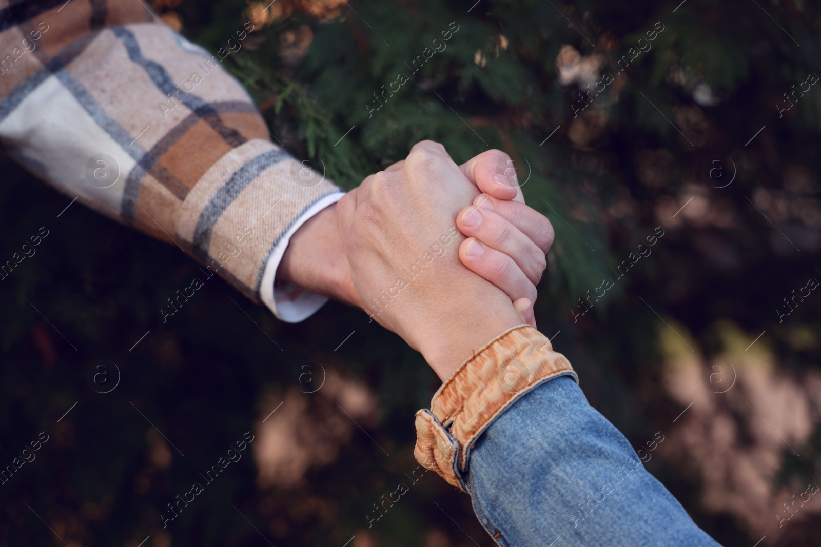 Photo of Help and support. People holding hands outdoors, closeup