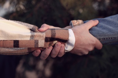 Help and support. People holding hands outdoors, closeup