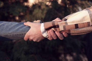 Help and support. People holding hands outdoors, closeup