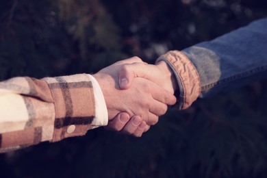 Help and support. People holding hands outdoors, closeup